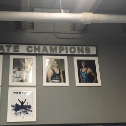 Photos of state wrestling champions on the wall in the AAHS dedicated wrestling practice area.
